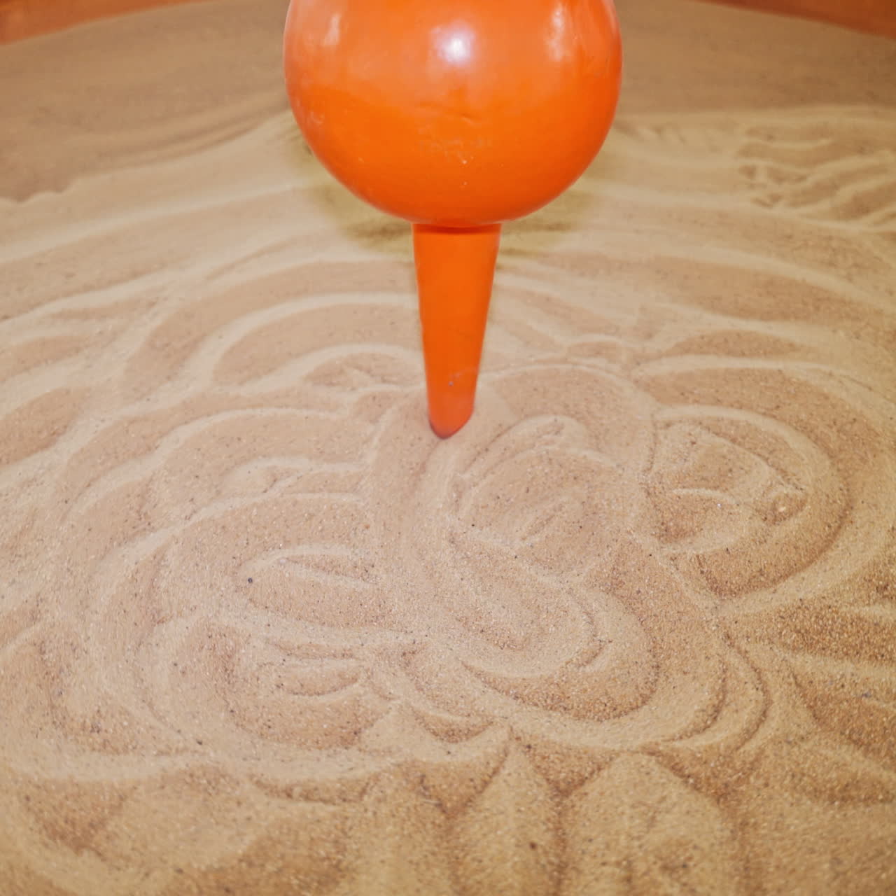 The pendulum draws on the sand. Science exhibition museum.