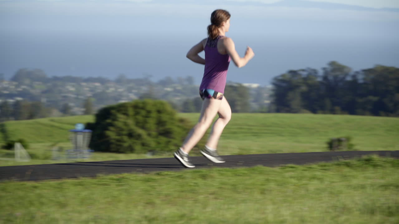mujer joven corriendo en una pista al atardecer