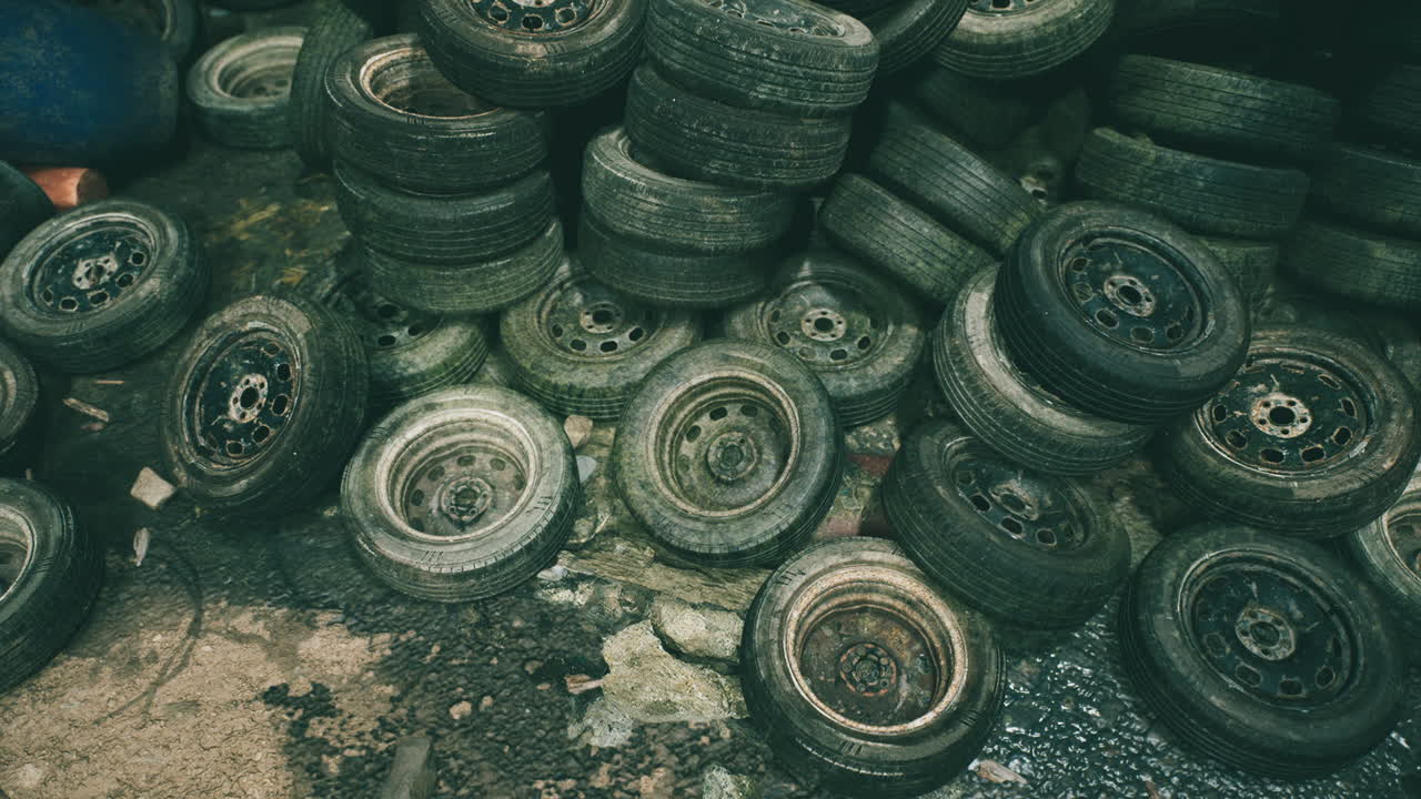 Abandoned tires stacked in a cluttered workshop creating a chaotic atmosphere