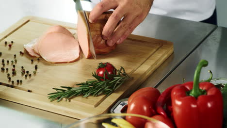 close up view of chef hands slicing hum in slow motion