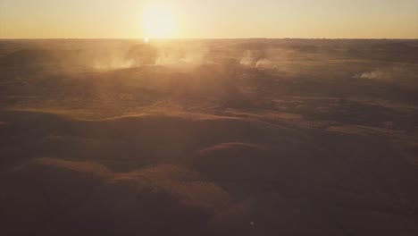 aerial drone flying over vast australian desert into smokey bush fire