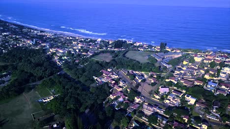 Drohne-Fliegt-über-Einige-Wohnhäuser-Und-Eine-Grundschule-Mit-Meerblick-Im-Hintergrund-Am-Bluff-Brighton-Beach