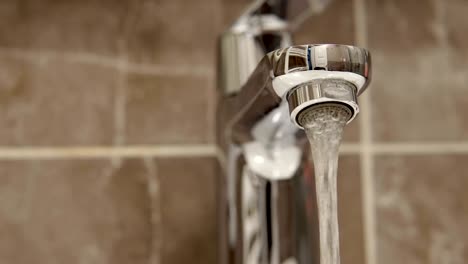 water tap with flowing water. loop background. selective focus, shallow depth of field, cinematic dof