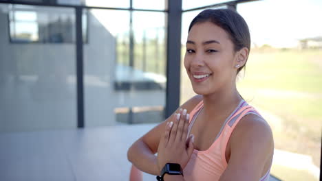 smiling woman in sportswear practicing yoga at home, hands in prayer position, copy space