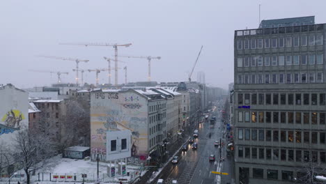 Imágenes-Elevadas-De-Edificios-Alrededor-De-La-Intersección-De-La-Calle-En-El-Barrio-Urbano.-Grupo-De-Grúas-Torre-En-El-Sitio-De-Construcción-En-Segundo-Plano.-Clima-Invernal-Con-Nieve.-Berlín,-Alemania