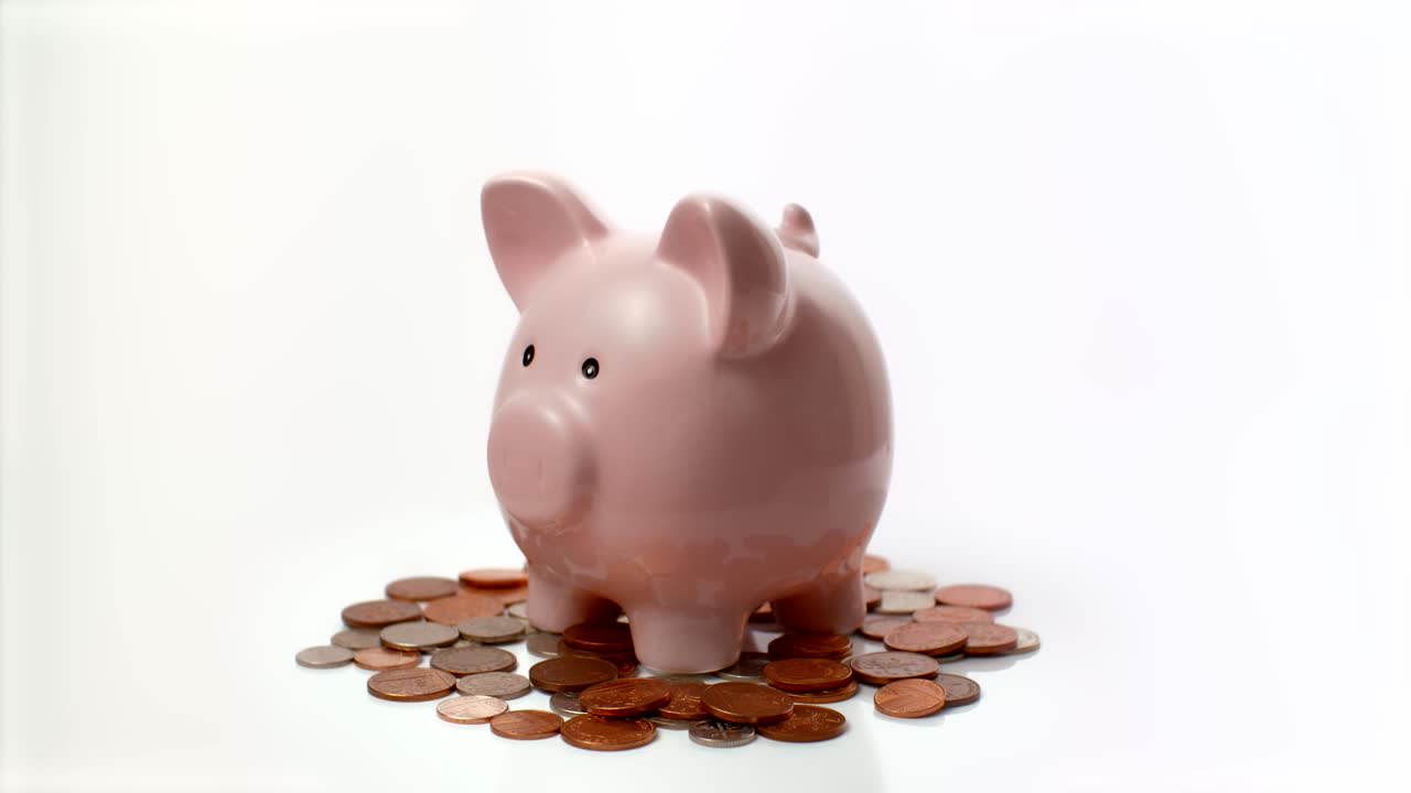 영국 동전에 앉아있는 돼지 저금통