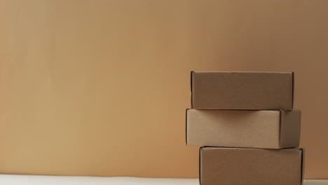 video of stacked cardboard boxes with copy space over brown background