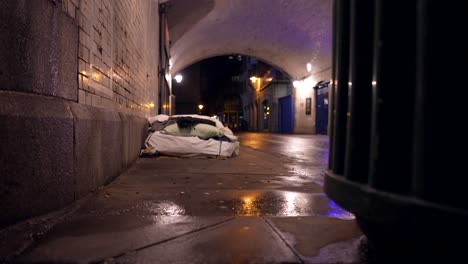 colchón de cama sin hogar en un túnel en londres por la noche, en un día lluvioso, charcos en el suelo, problemas de pobreza en las ciudades
