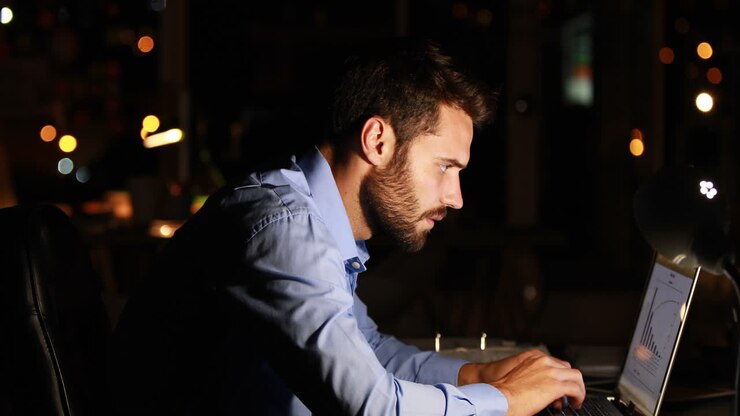 Businessman using laptop at night