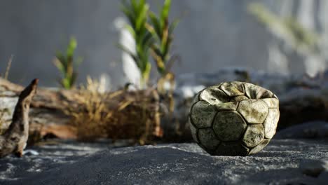 una vieja pelota de fútbol rota arrojada yace en la arena de la playa del mar