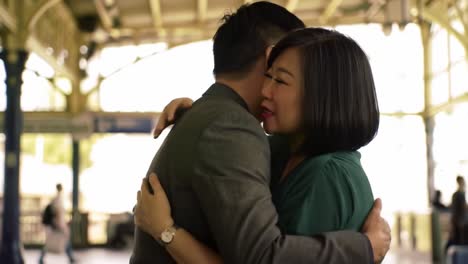 a heartfelt reunion: two individuals embrace in a tender moment at a busy transport hub, capturing raw emotion amidst the hustle and bustle of city life