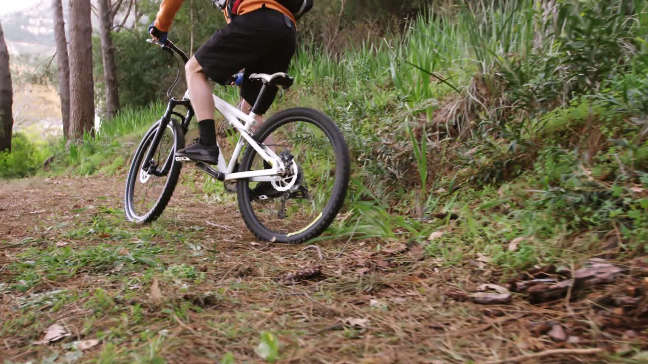 motociclista de montaña masculino montando en el bosque