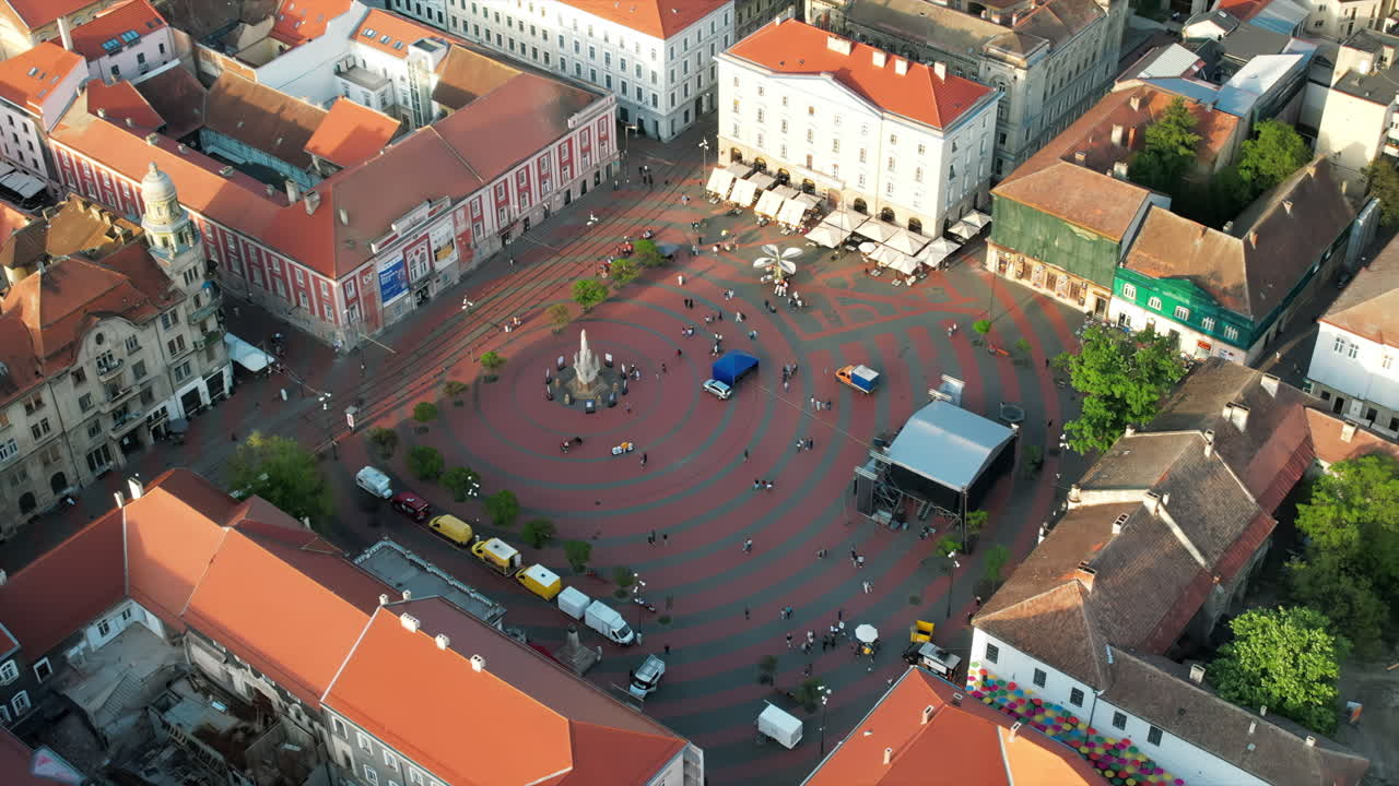 Aerial drone view of Timisoara at sunset, Romania. View of the city downtown, Freedom Square with people and multiple historical buildings around