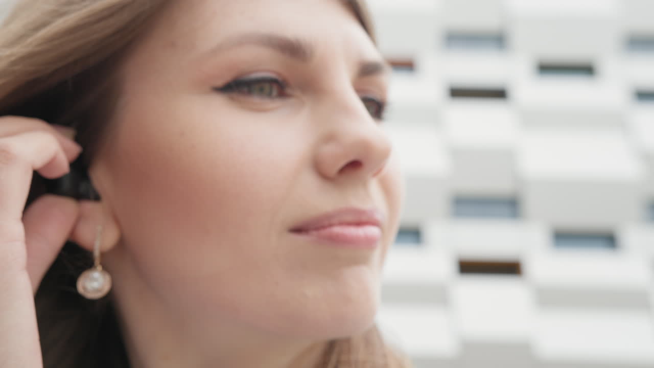 joven mujer de negocios disfrutando de la música favorita de la lista de reproducción en el teléfono inteligente a través de auriculares modernos con