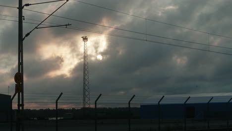 hermoso lapso de tiempo lento de las nubes que pasan frente al sol durante la puesta de sol, zona industrial, gaviotas volando, puerto
