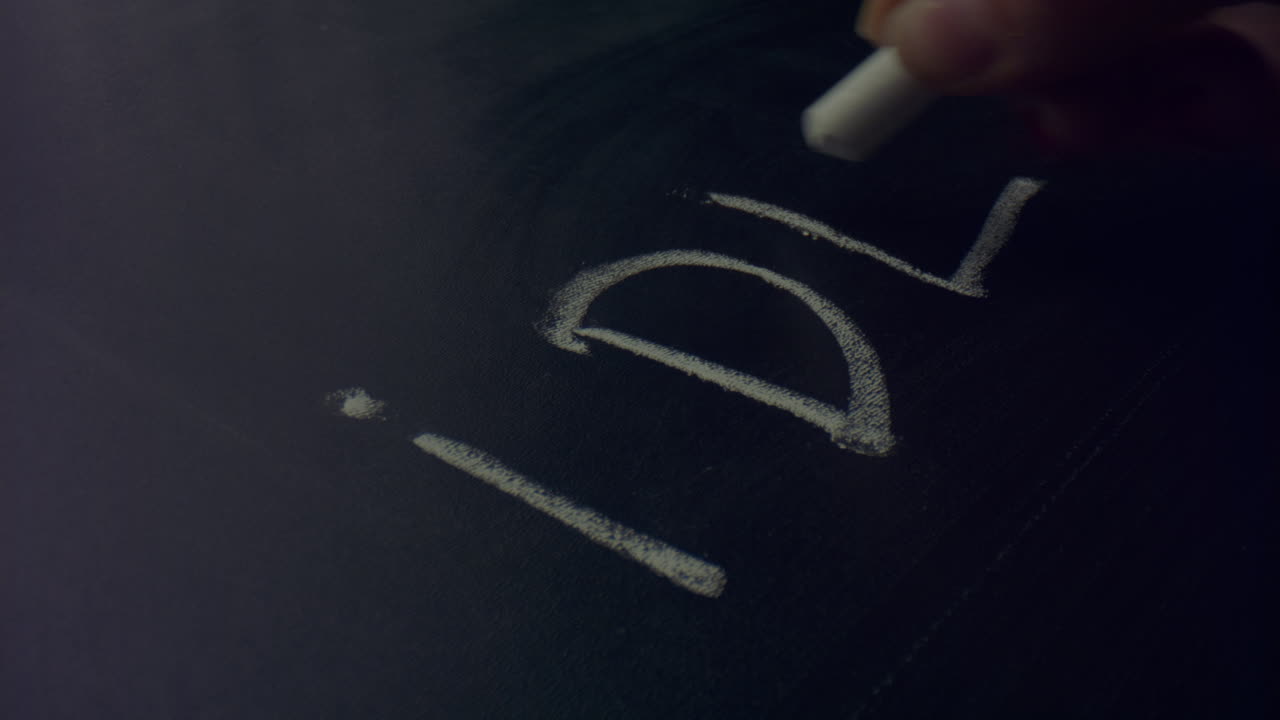 женщина с мелом на руке. непризнанный человек пишет текст на доске.