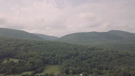 aerial view of lush green forested mountains under an overcast sky