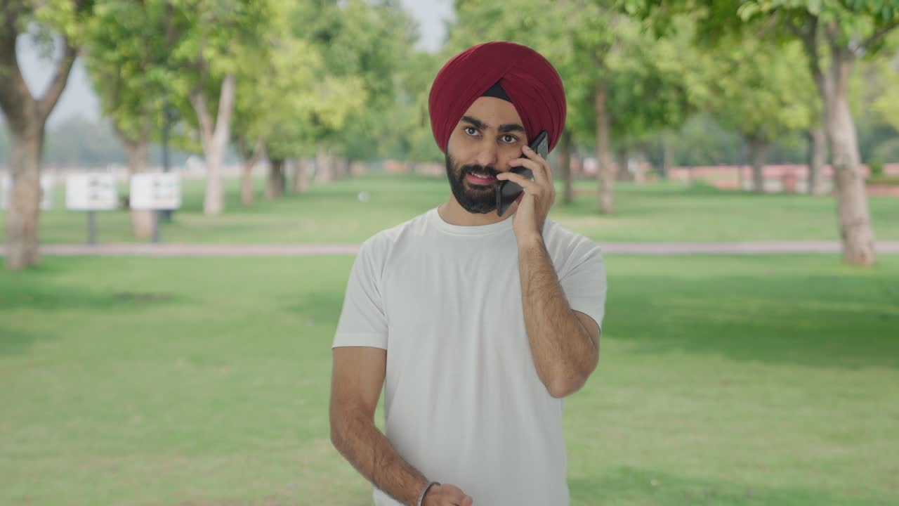 Uomo indiano arrabbiato che urla al telefono nel parco