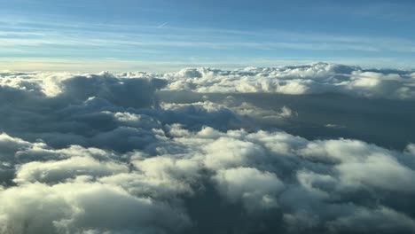 aerila view from a cockpit overflying few clouds with afernoon light