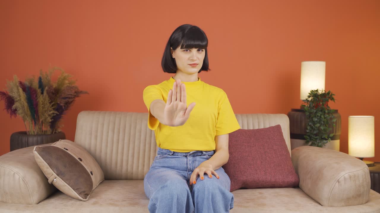 여성이 카메라를 위해 정지 표지판을 만들고 있습니다.