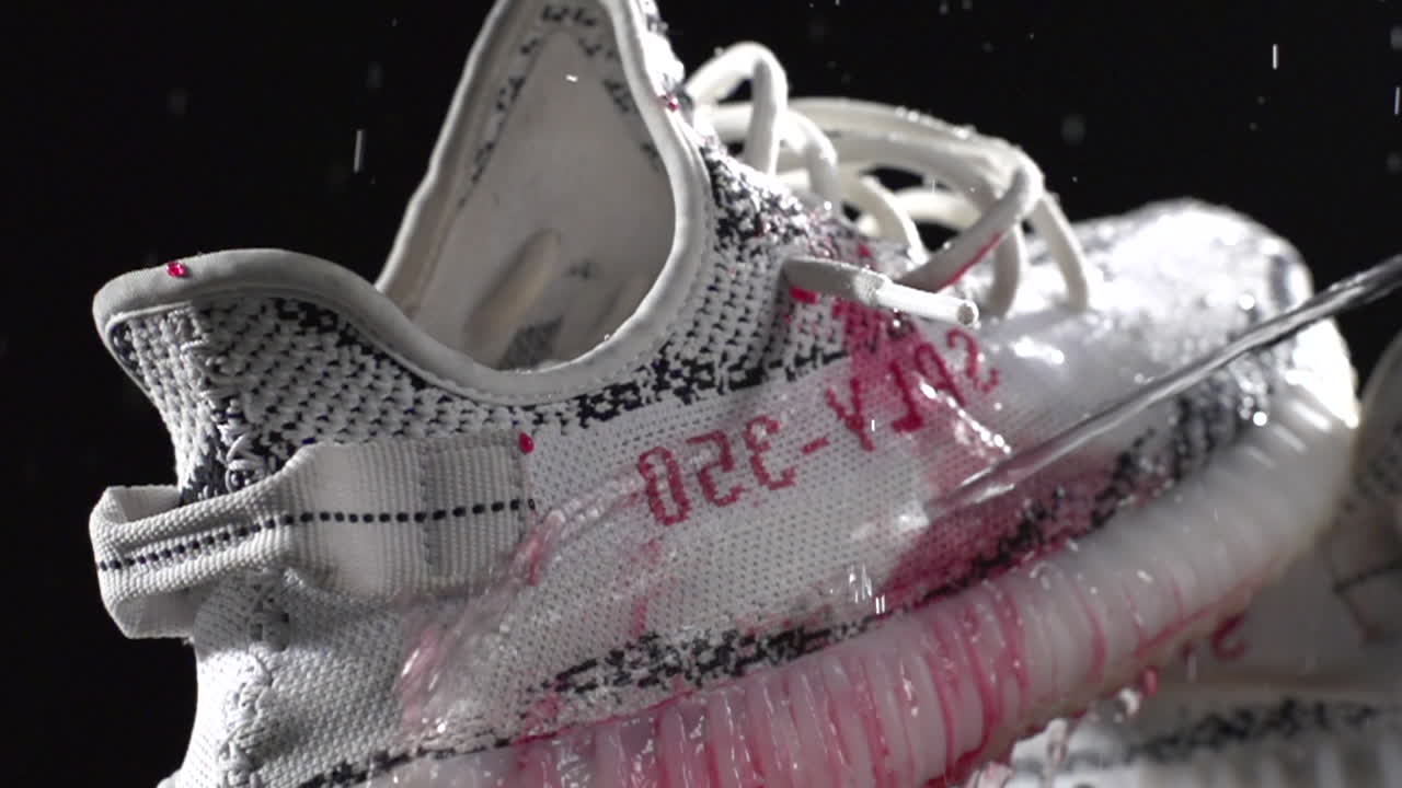 SLOW MOTION pouring water clean red syrup on waterproof white sneaker