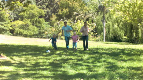 Family-in-slow-motion-running-with-a-soccer-ball