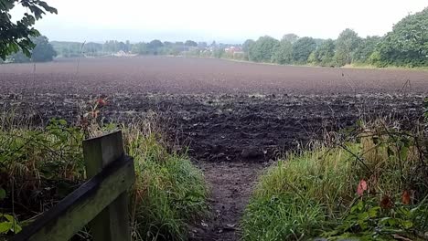 agricultural muddy ploughed fertile farmers field in the rural british countryside, slow rising shot