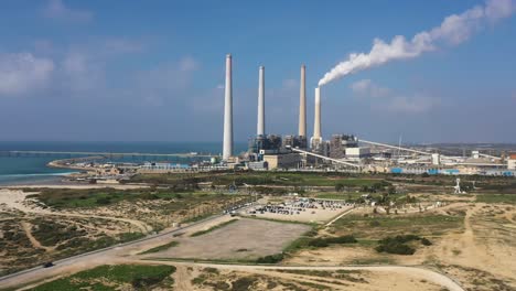 hadera park, orot rabin power plant aerial tracking shot with blue sky and view of the mediterranean sea