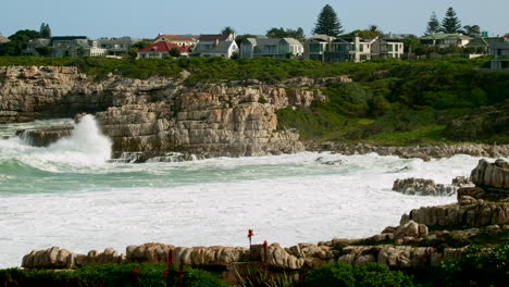 Die-Küstengrundstücke-In-Hermanus-überblicken-Die-Meereswellen,-Die-Gegen-Die-Felsige-Küste-Krachen