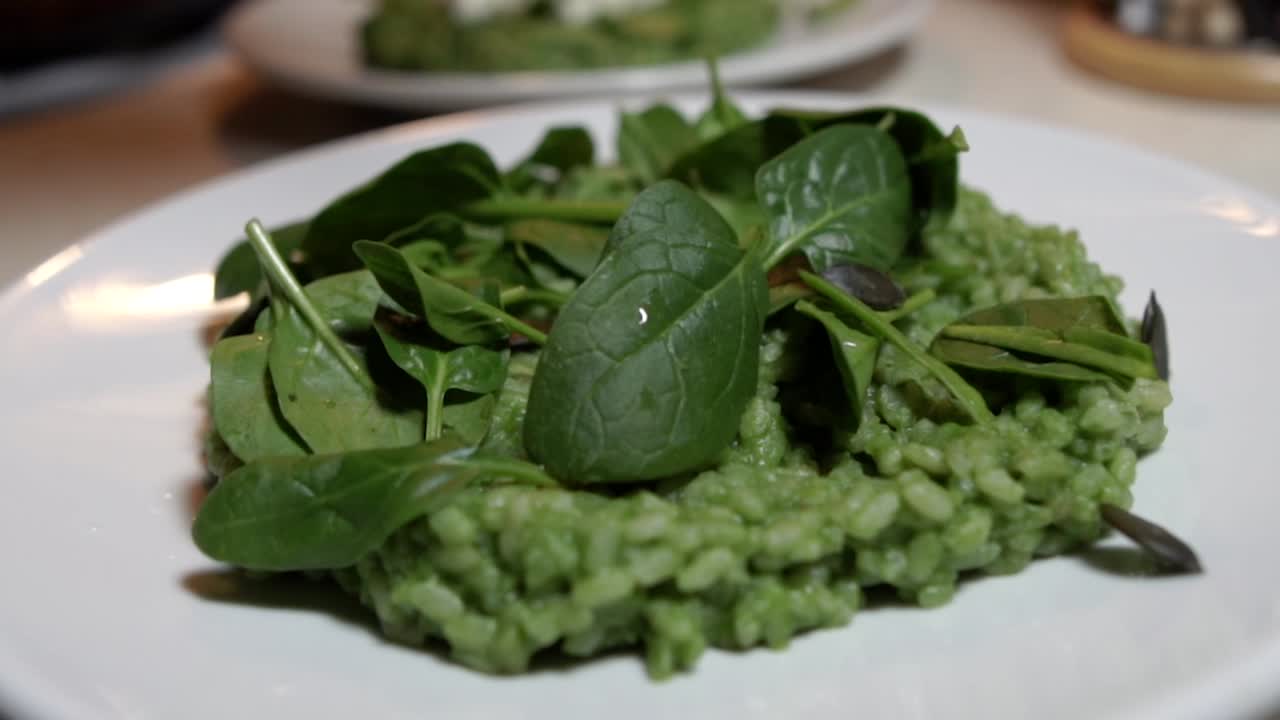 guarnición de risotto de espinacas verdes con semillas de calabaza secas, cámara lenta