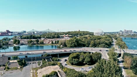 aerial drone footage of montreal with bridges and a park area plus ile sainte helene island with the biosphere dome in the background