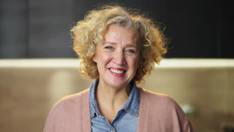 portrait of a smiling woman with blonde curly hair