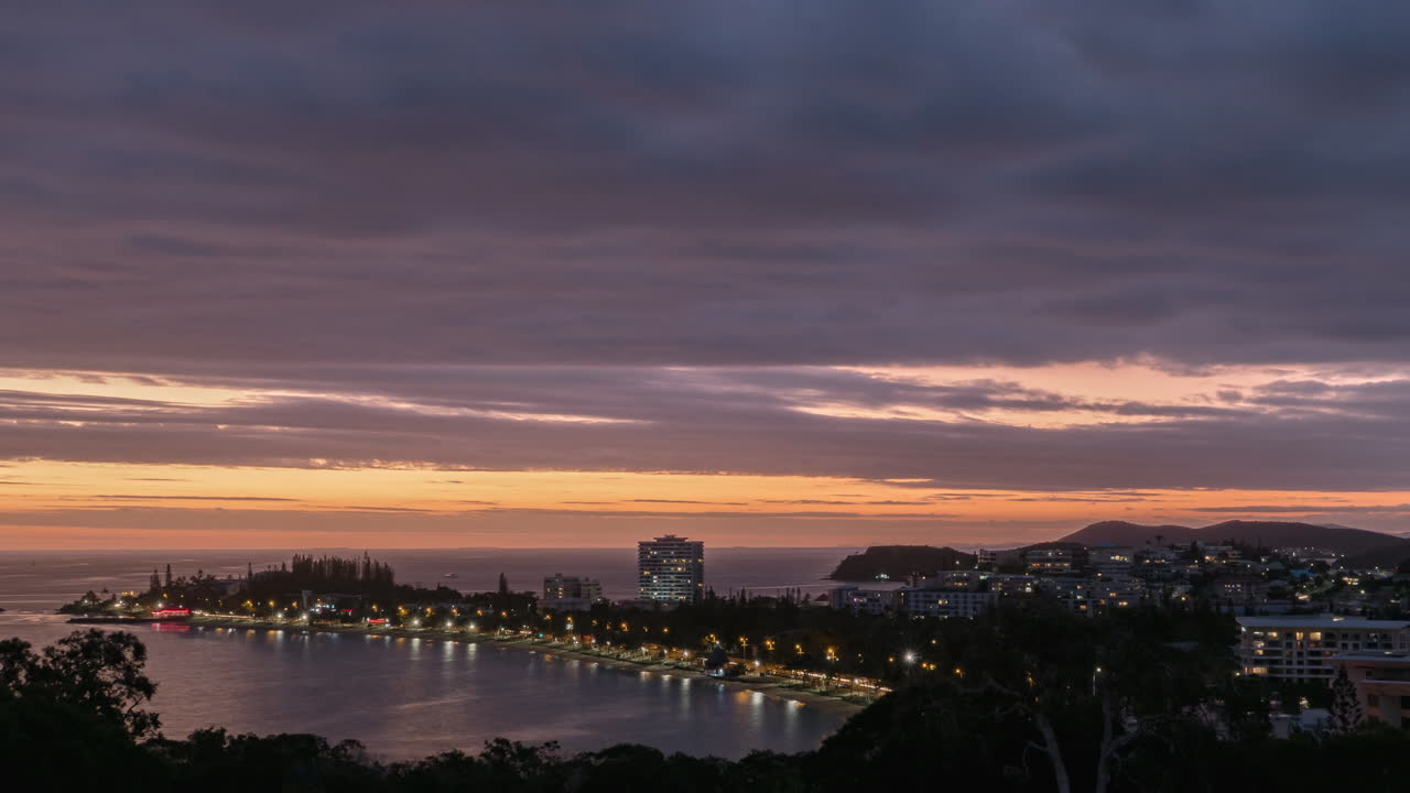 뉴 칼레도니아의 안세 바타 해변의 일몰 시간 경과와 유명한 산책로 피에르 베르니에에서 운전하는 야간 교통