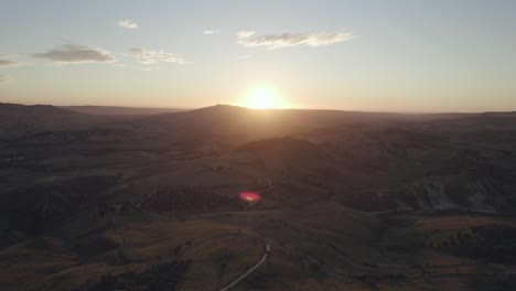 drone volando de lado filmando un paisaje italiano con colinas, árboles y campos de hierba al amanecer en 4k