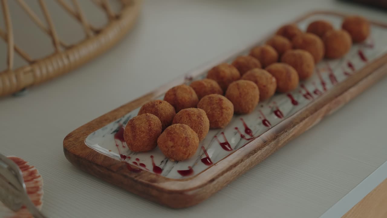 crocchette dorate disposte con cura su un piatto di legno