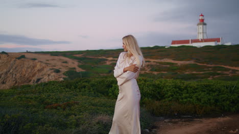 mujer tranquila relajándose retrato de la naturaleza verticalmente. chica rubia posando sonriendo puesta de sol