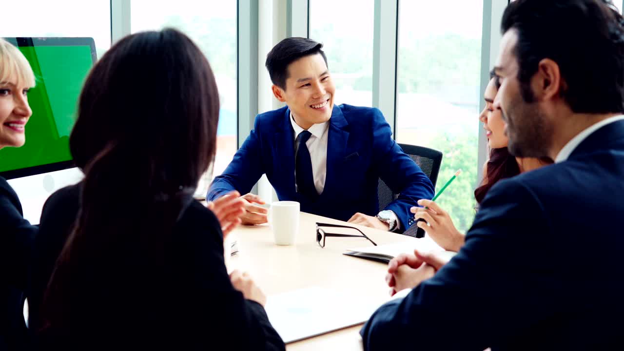 녹색 스크린을 가진 회의실에 있는 비즈니스 사람들