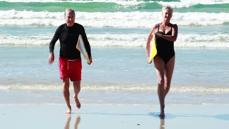 Pareja-Mayor,-Con,-Tabla-De-Surf,-Funcionamiento,-En,-Playa