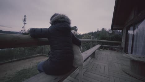 hd of a woman and her dog outdoog house in front of a lake