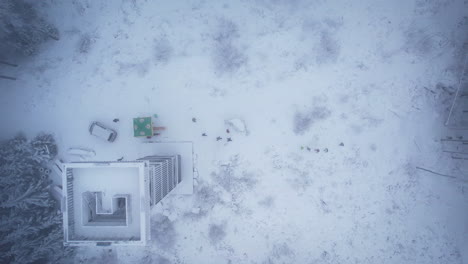 Aerial-view-of-people-walking-in-winter-snow-covered-landscape-with-trees-and-lookout-tower