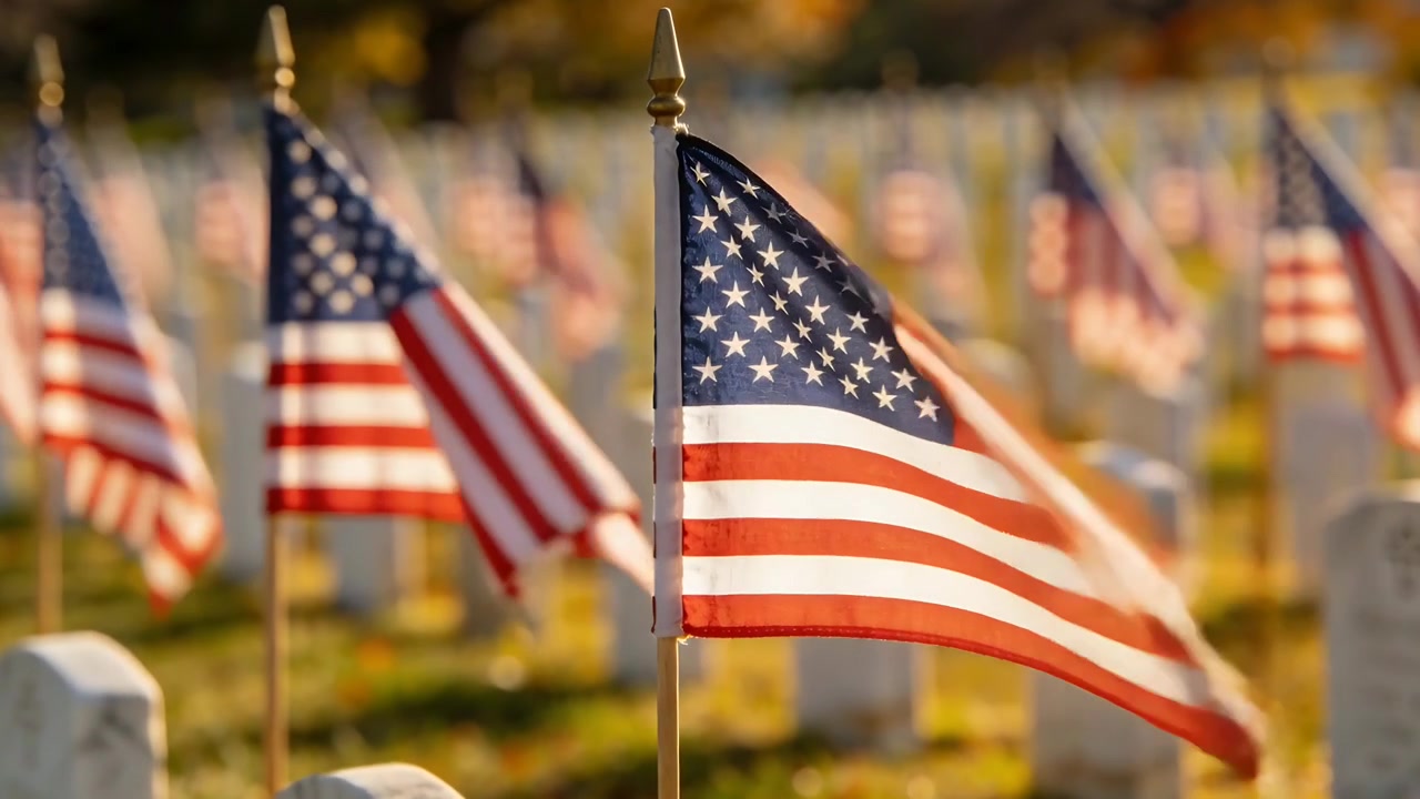Waving front American flag rippling in breeze picking up among white headstones for veterans