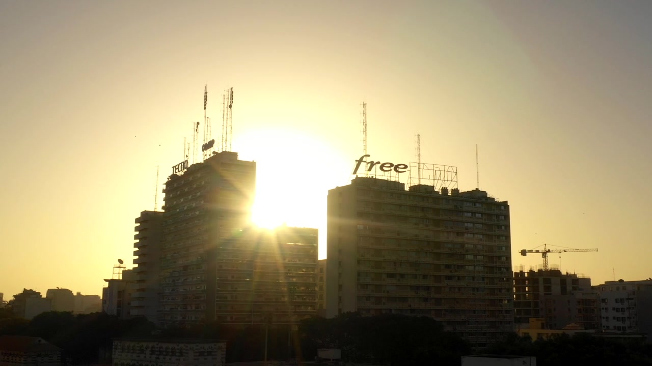Arranha-céus altos em silhueta ao nascer do sol em uma cidade africana moderna. Crescimento e desenvolvimento urbano em comunidades mais pobres