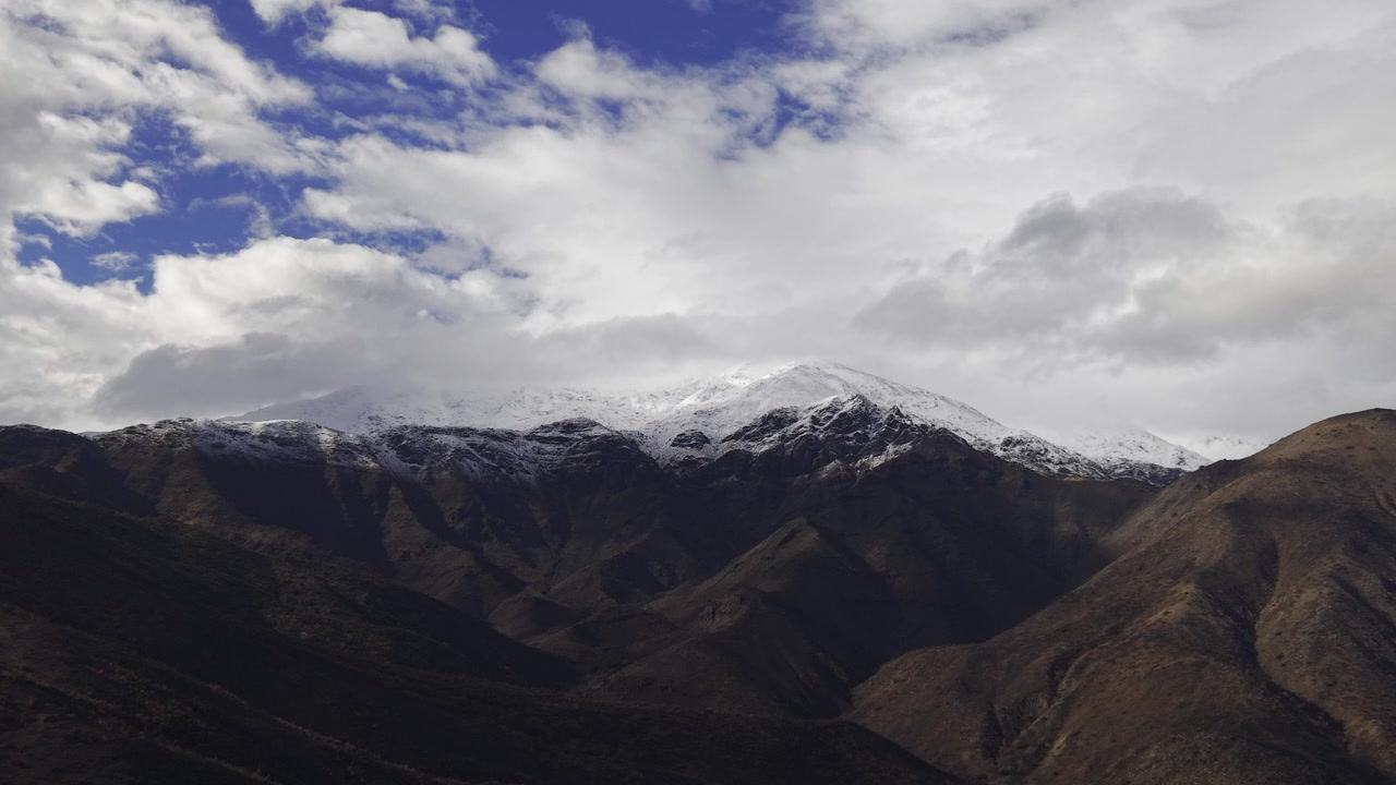 Captura deslumbrante de drone em ângulo alto da cordilheira dos Andes no Chile, apresentando vales profundamente sombrios que levam a picos nevados de inverno