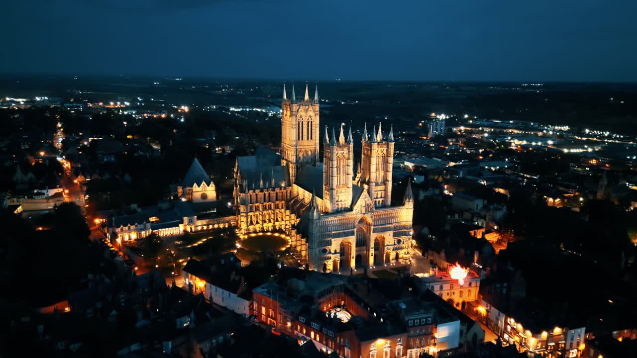 공중 드론 비디오는 영국의 링컨셔에 있는 유명한 링컨 대성당을 어두워지면서 촬영하고 있으며, 그 웅장한 고 ⁇  건축을 조명으로 보여줍니다.