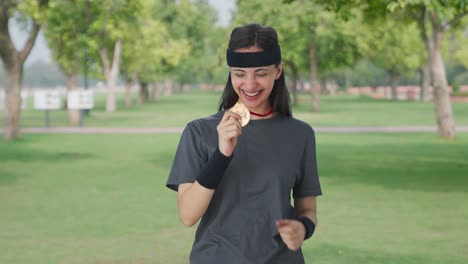 happy indian girl celebrating with medal