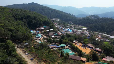 slow drone rotating shot over typical mountain village in thailand with market