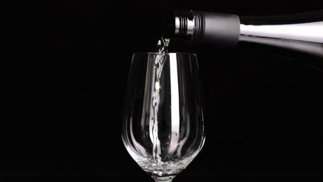 professional pouring white wine into wineglass isolated on black background