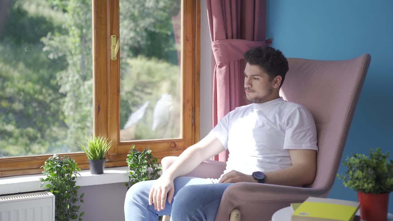 감성적인 남자가 창 밖을 지켜보고 있습니다.