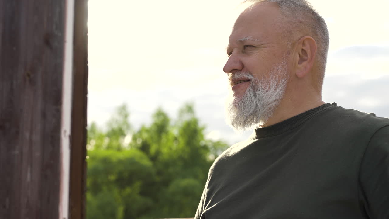 un hombre barbudo tomando una copa al aire libre