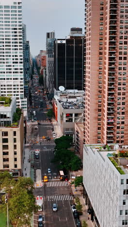 footage above the busy wide road going along futuristic modern architecture. new york view from top. vertical video